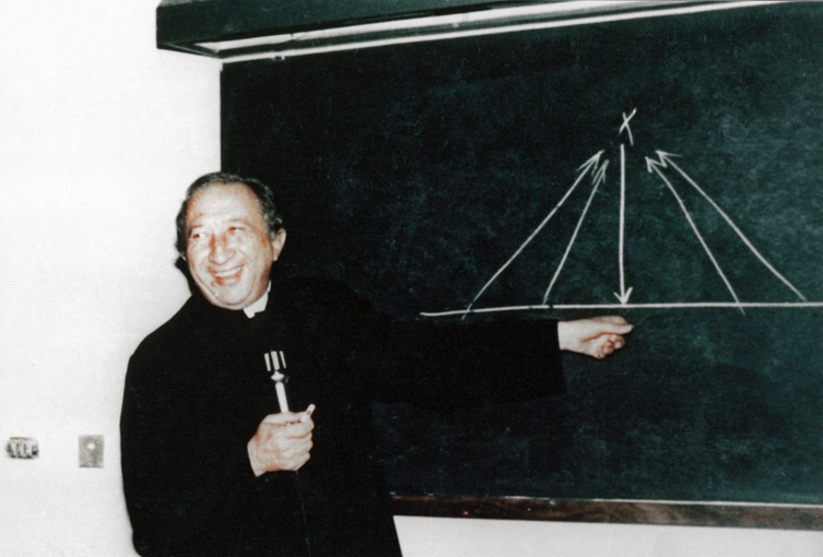Années 80. Milan. Don Luigi Giussani explique par le « graphique du X » l’incarnation de Dieu. © Fraternité de CL